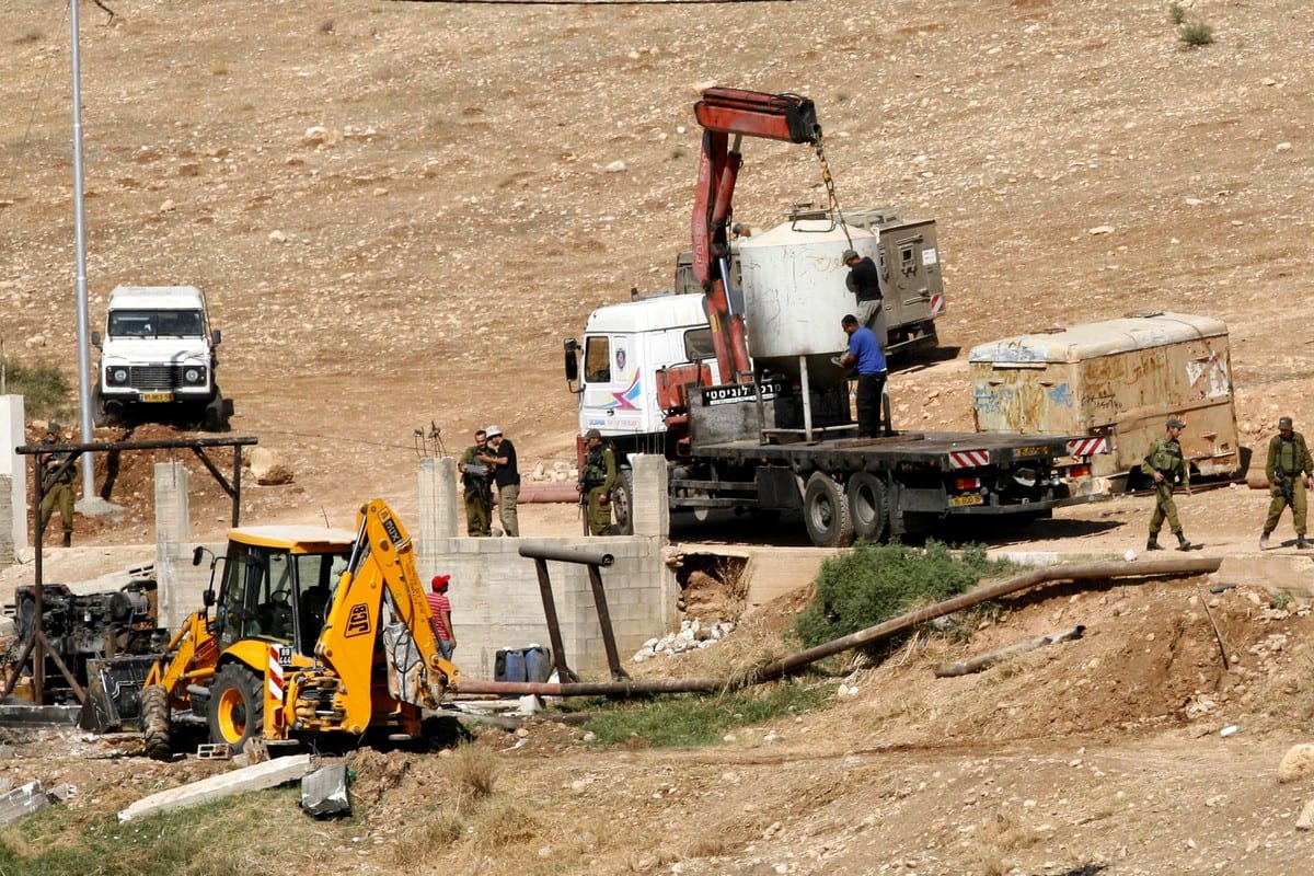 Israeli soldiers surround a bulldozer as it destroys a Palestinian water well in the West Bank [Wagdi Eshtayah/ApaImages]